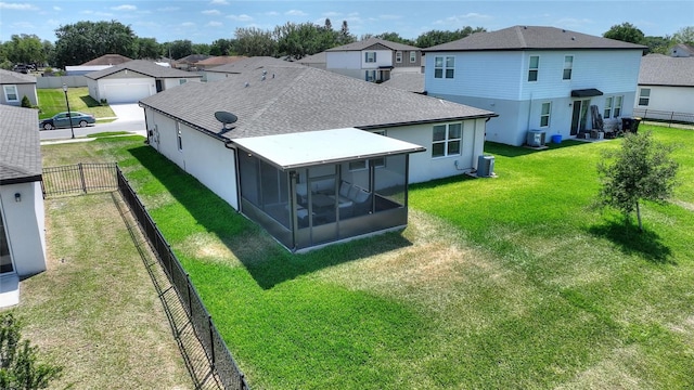 back of property with a residential view, a sunroom, roof with shingles, and central AC unit