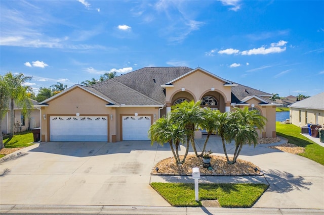 ranch-style house with a garage, driveway, and stucco siding
