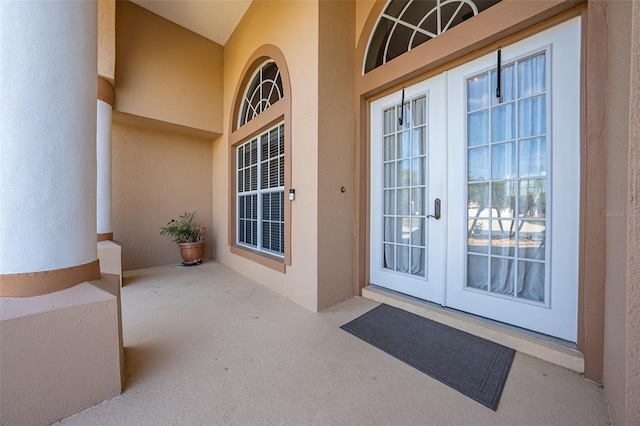 entrance to property featuring french doors and stucco siding