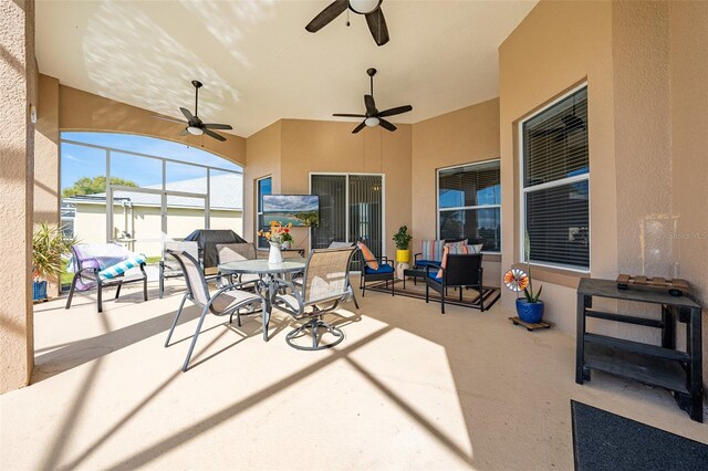 view of patio / terrace with glass enclosure, outdoor lounge area, a ceiling fan, and outdoor dining area