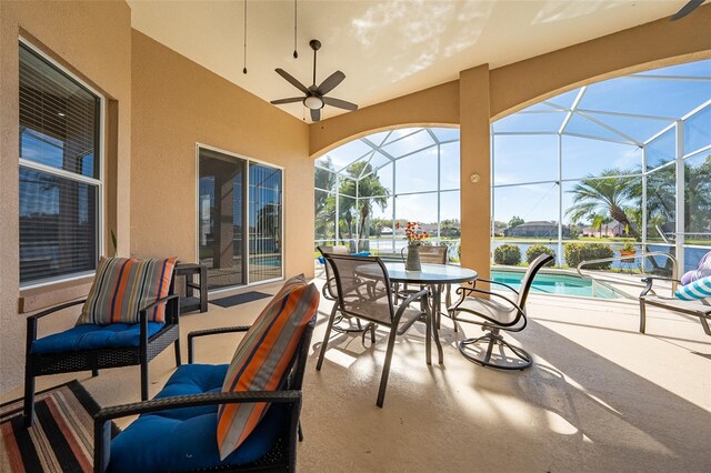 sunroom featuring ceiling fan and a pool