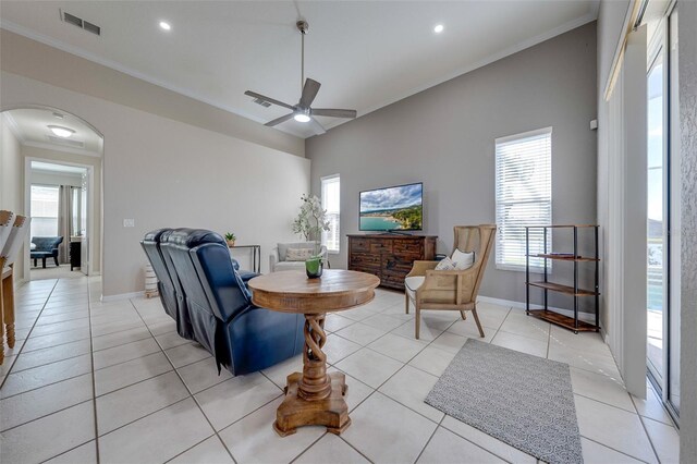 living area featuring visible vents, a wealth of natural light, ceiling fan, and crown molding