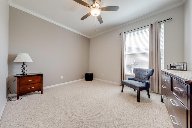 sitting room with light carpet, crown molding, baseboards, and a ceiling fan