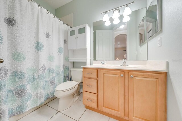 bathroom with curtained shower, tile patterned flooring, vanity, and toilet