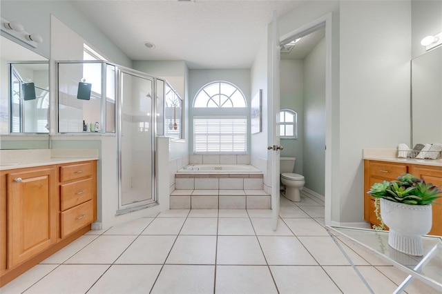 bathroom with a garden tub, vanity, a shower stall, and toilet