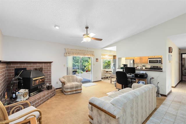 living area with baseboards, a ceiling fan, lofted ceiling, and a wood stove