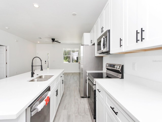 7744 Sun N Lake Blvd, Sebring, FL 33872 - kitchen with a sink, light wood-style floors, ceiling fan, white cabinets, and appliances with stainless steel finishes
