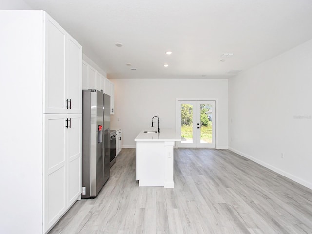 7744 Sun N Lake Blvd, Sebring, FL 33872 - kitchen featuring french doors, a sink, baseboards, white cabinetry, and stainless steel refrigerator with ice dispenser
