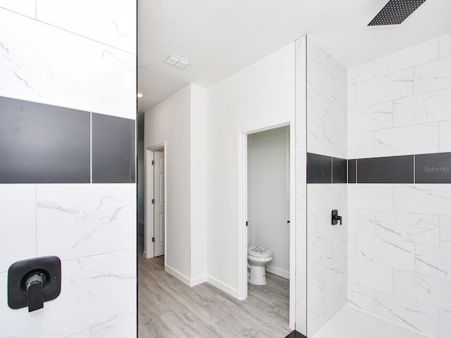 7744 Sun N Lake Blvd, Sebring, FL 33872 - full bathroom with a tile shower, toilet, wood finished floors, and baseboards