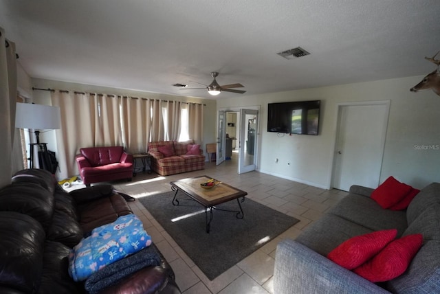 tiled living area with baseboards, a ceiling fan, and visible vents
