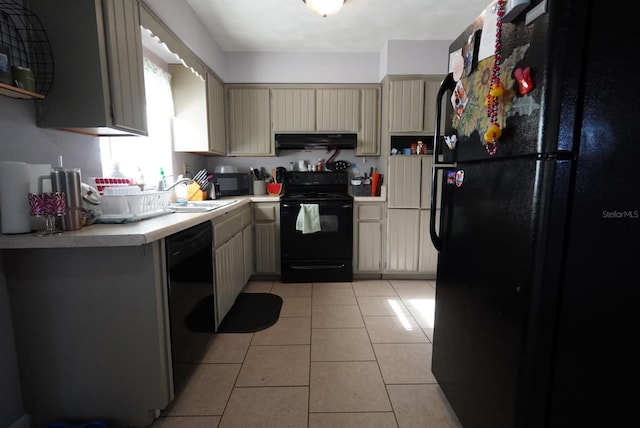 kitchen featuring cream cabinetry, under cabinet range hood, light countertops, a sink, and black appliances