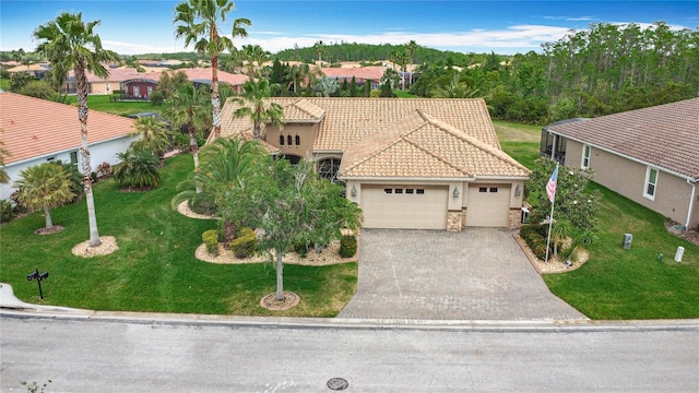 view of front of home featuring a front yard, a residential view, an attached garage, driveway, and a tile roof