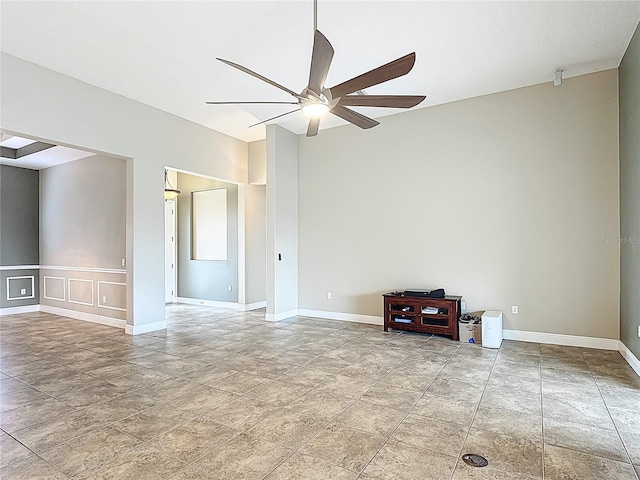 unfurnished room featuring baseboards, ceiling fan, and stone finish floor