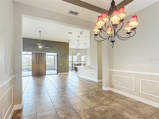 empty room featuring baseboards, visible vents, and ceiling fan with notable chandelier