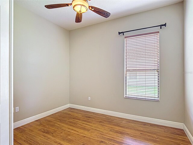 empty room featuring baseboards, a ceiling fan, and wood finished floors