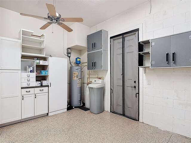 interior space with ceiling fan, concrete block wall, and electric water heater
