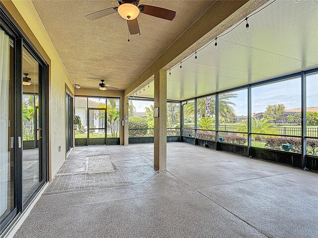 unfurnished sunroom featuring a ceiling fan