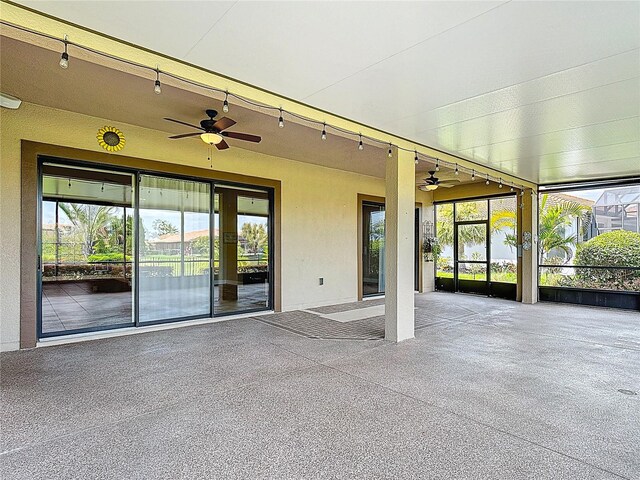 unfurnished sunroom featuring a ceiling fan