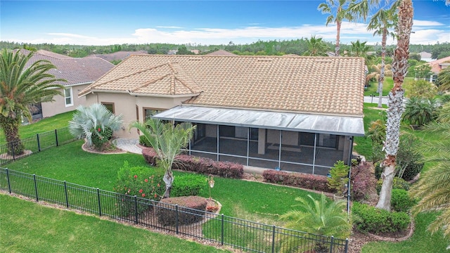 view of front facade with a sunroom, a fenced backyard, a front lawn, and a tiled roof
