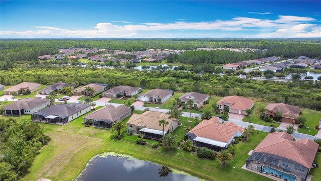bird's eye view featuring a water view, a view of trees, and a residential view