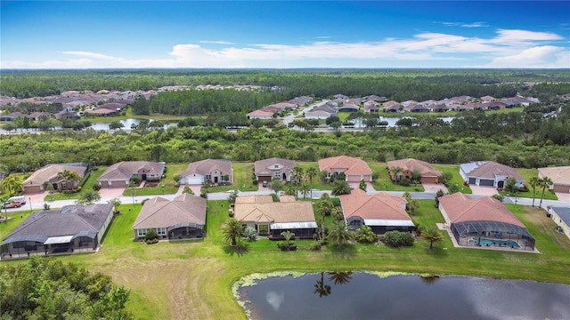 bird's eye view with a water view, a view of trees, and a residential view