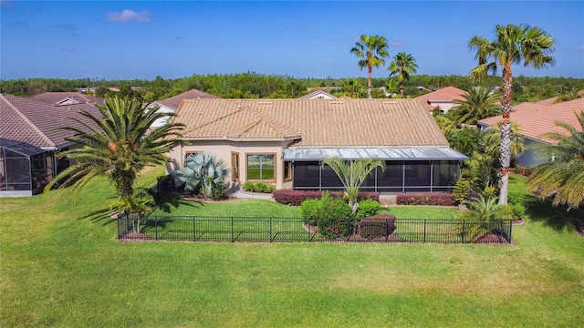 view of front of home with a front yard, a fenced backyard, and a sunroom