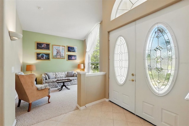 2374 Eagle Trace Dr, Kissimmee, FL 34746 - foyer with baseboards, light tile patterned floors, a healthy amount of sunlight, and light colored carpet