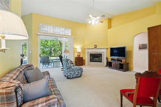 2374 Eagle Trace Dr, Kissimmee, FL 34746 - living area with light colored carpet, ceiling fan, a tiled fireplace, and a high ceiling