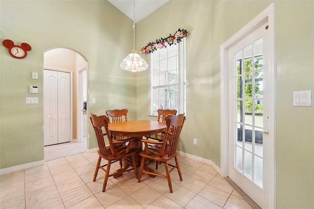 2374 Eagle Trace Dr, Kissimmee, FL 34746 - dining area featuring baseboards, light tile patterned floors, arched walkways, and a high ceiling