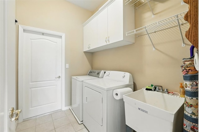 2374 Eagle Trace Dr, Kissimmee, FL 34746 - laundry room with light tile patterned floors, washing machine and clothes dryer, a sink, baseboards, and cabinet space