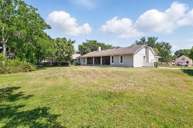 2374 Eagle Trace Dr, Kissimmee, FL 34746 - rear view of house with a sunroom, a lawn, stucco siding, and a chimney