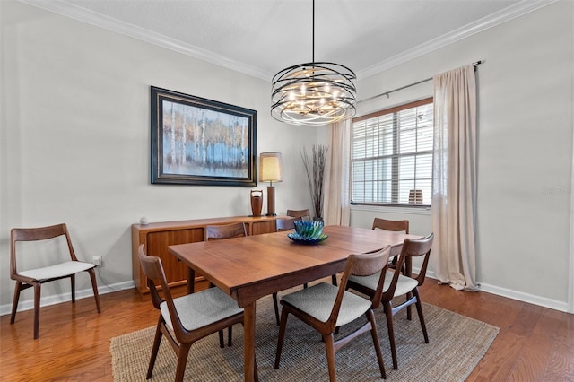 dining area featuring baseboards, wood finished floors, a notable chandelier, and crown molding