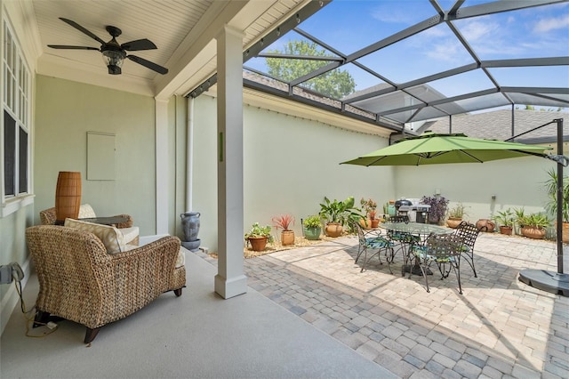 view of patio featuring a lanai, outdoor dining space, and a ceiling fan