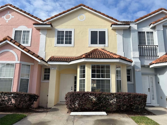 view of front facade featuring a tiled roof and stucco siding