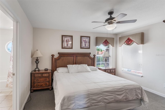 301 Rosso Dr, Davenport, FL 33837 - bedroom with baseboards, ceiling fan, ensuite bath, and light colored carpet