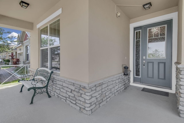 2487 Empress Dr, Kissimmee, FL 34741 - doorway to property featuring covered porch, stone siding, and stucco siding