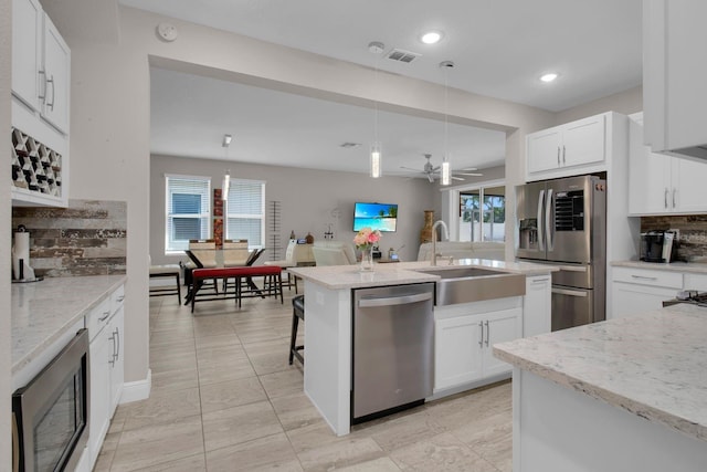 2487 Empress Dr, Kissimmee, FL 34741 - kitchen with decorative backsplash, decorative light fixtures, visible vents, a sink, and stainless steel appliances
