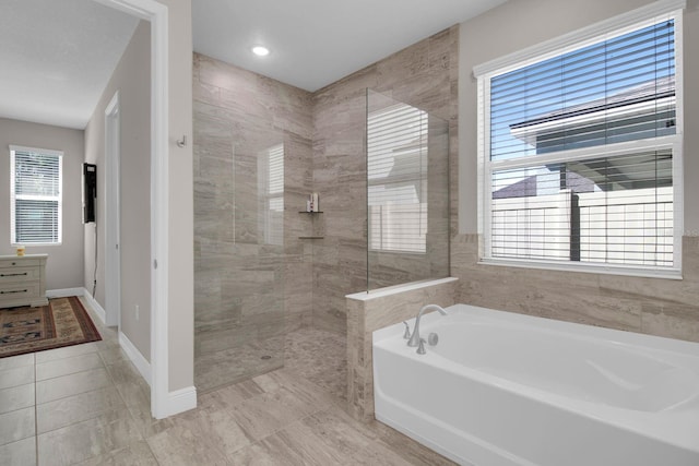 2487 Empress Dr, Kissimmee, FL 34741 - full bathroom with tile patterned floors, walk in shower, plenty of natural light, and a bath