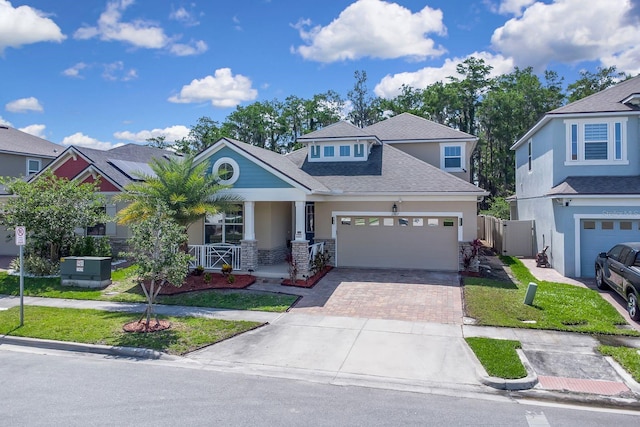 2487 Empress Dr, Kissimmee, FL 34741 - craftsman inspired home with a shingled roof, a garage, stucco siding, a porch, and decorative driveway