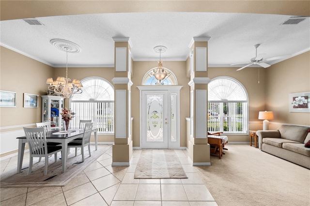 entrance foyer with a wealth of natural light, ornamental molding, and light tile patterned flooring