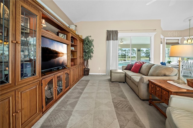 living area with a ceiling fan, light colored carpet, and baseboards