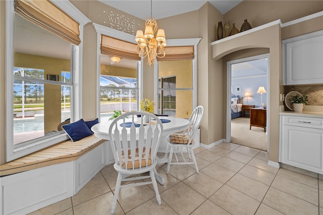 dining space with light tile patterned floors, an inviting chandelier, and baseboards