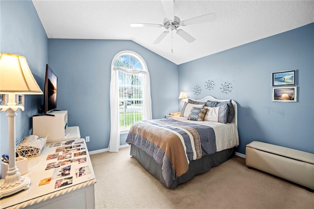 bedroom with light colored carpet, ceiling fan, baseboards, a textured ceiling, and lofted ceiling
