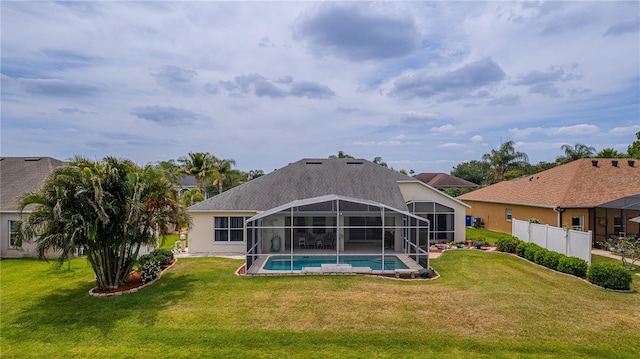 back of property featuring a lanai, a yard, and an outdoor pool