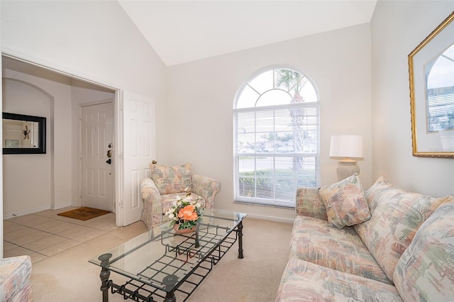 living room with carpet floors, tile patterned floors, and high vaulted ceiling