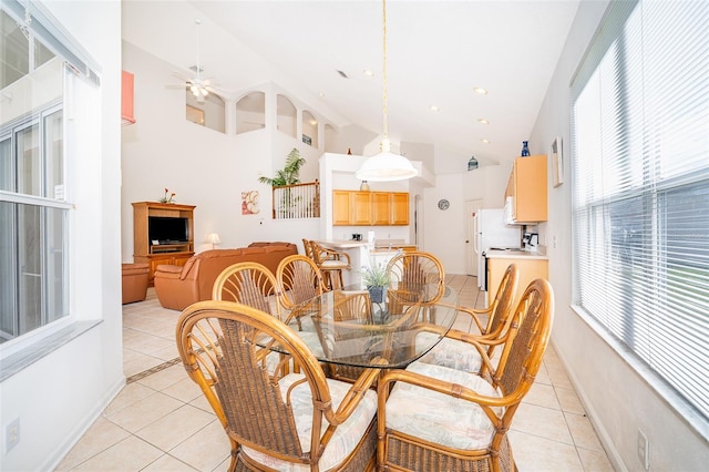 dining room with a ceiling fan, light tile patterned flooring, and high vaulted ceiling