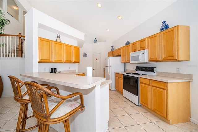 kitchen featuring white appliances, light countertops, a breakfast bar area, light tile patterned floors, and lofted ceiling