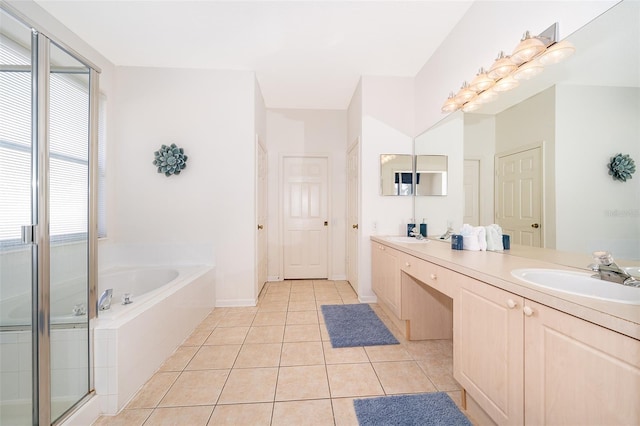 bathroom featuring a sink, tile patterned flooring, double vanity, a bath, and a stall shower