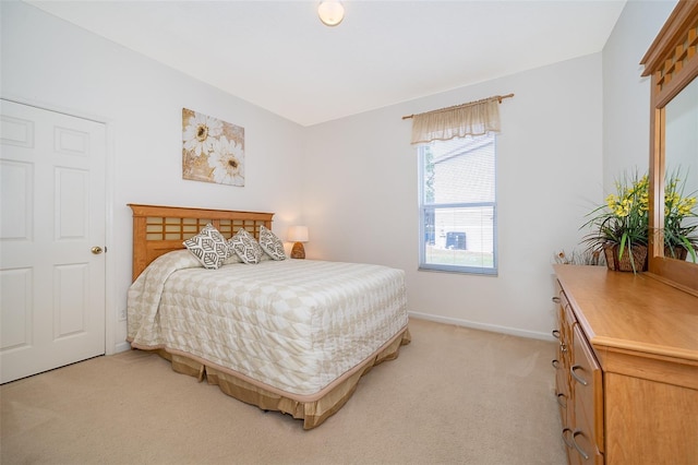 bedroom with light colored carpet and baseboards