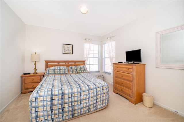 bedroom with baseboards and light carpet